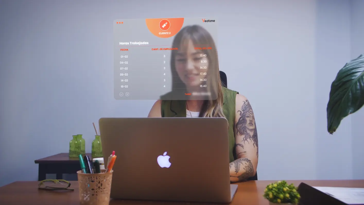 Empleado analizando reporte de horas trabajadas en pantalla.
